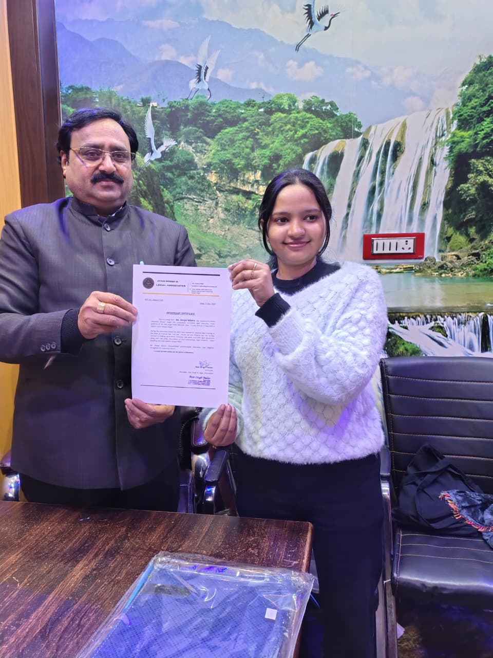 Handing over an internship certificate to a law student.